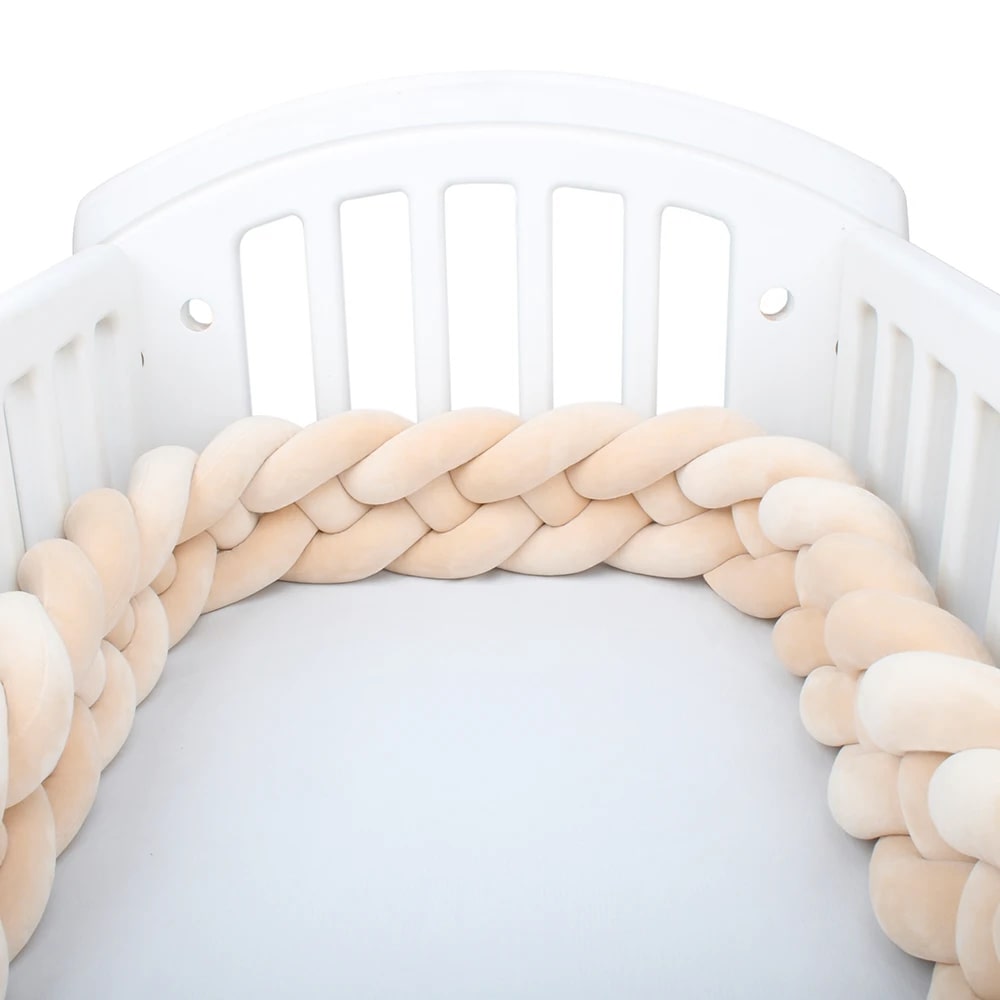 Tour de lit tressé beige 4 brins, sécurité et confort pour chambre bébé.