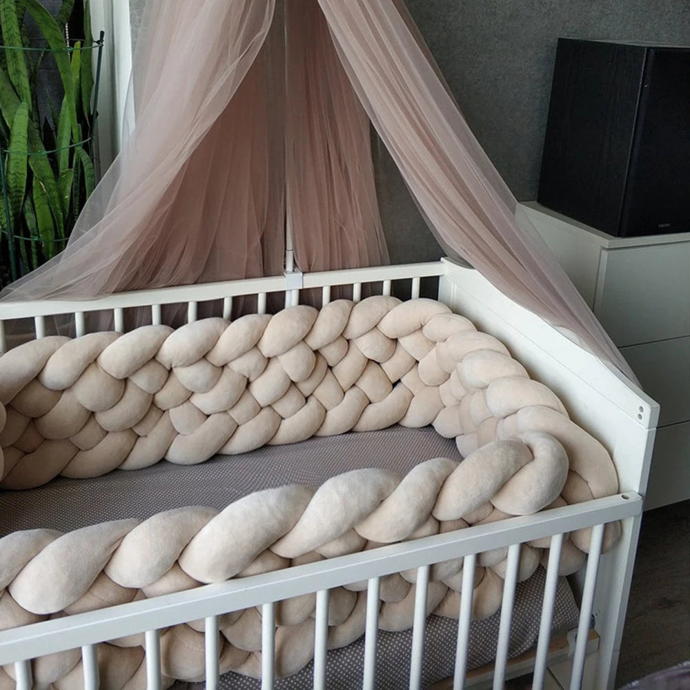 Tour de lit tressé beige 6 brins dans une chambre bébé décorée, sécurisation du couchage.